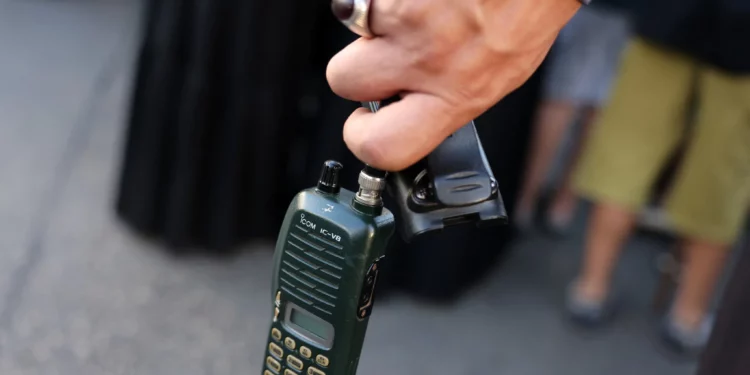 Un hombre sostiene un walkie-talkie después de quitarle la batería durante el funeral de las personas que murieron cuando cientos de dispositivos bíperes explotaron en un presunto ataque israelí contra Hezbolá en el Líbano el día anterior, en los suburbios del sur de Beirut el 18 de septiembre de 2024. (Anwar Amro/AFP)