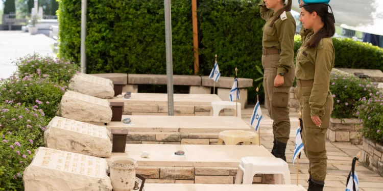 Los soldados colocan flores y banderas en las tumbas de los soldados israelíes caídos en el cementerio militar de Kiryat Shmona, el 24 de abril de 2023, antes del Día de los Caídos en Israel. (Ayal Margolin/Flash90)