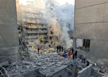 La gente se reúne mientras los rescatistas revisan los escombros de un edificio derribado, luego de un ataque aéreo israelí nocturno que tuvo como objetivo el barrio de Basta en Beirut el 23 de noviembre de 2024. (Fadel Itani/AFP)