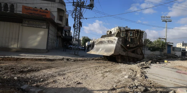 Una excavadora militar israelí avanza por una carretera durante una redada en la ciudad de Tulkarem, en el norte de Cisjordania, el 28 de agosto de 2024. (Jaafar ASHTIYEH / AFP)