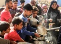 Gazatíes recogen ayuda alimentaria en el campamento de Bureij, en el centro de la Franja de Gaza, el 6 de noviembre de 2024. (Eyad Baba/AFP)