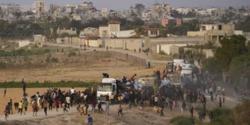 Gazatíes atacan camiones cargados con ayuda humanitaria traída a través de un nuevo muelle construido por Estados Unidos, en el centro de la Franja de Gaza, el 18 de mayo de 2024. (Foto AP/Abdel Kareem Hana, Archivo)