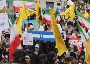 Las mujeres ondean banderas de Irán, Palestina y Hezbolá mientras llevan un ataúd simulado con la bandera israelí durante una manifestación frente a la antigua embajada de Estados Unidos en Teherán el 3 de noviembre de 2024 (ATTA KENARE / AFP)