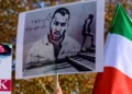 La gente sostiene carteles con retratos del rapero iraní Toomaj Salehi, quien fue arrestado en Irán, y retratos de niños (izq.), quienes fueron asesinados durante las protestas en Irán, durante una manifestación en apoyo de las mujeres iraníes en Estambul, el 26 de noviembre de 2022. (Yasin AKGUL / AFP)