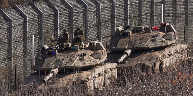 Soldados israelíes se sientan sobre un tanque a lo largo de la llamada Línea Alfa que separa los Altos del Golán de Siria, en la ciudad de Majdal Shams, el 9 de diciembre de 2024. (AP/ Matias Delacroix)