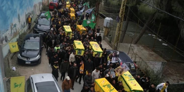 Los dolientes llevan los ataúdes de los combatientes de Hezbolá que murieron durante la reciente guerra con Israel, durante su procesión fúnebre en la aldea de Kherbet Selm, en el sur del Líbano, el 4 de diciembre de 2024. (MAHMOUD ZAYYAT / AFP)