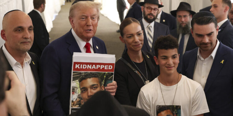El entonces expresidente estadounidense Donald Trump posa para fotografías con familiares del rehén de Hamás Edan Alexander, después de visitar la tumba del rabino Menachem Mendel Schneerson en Nueva York, el 7 de octubre de 2024. (Foto AP/ Yuki Iwamura)