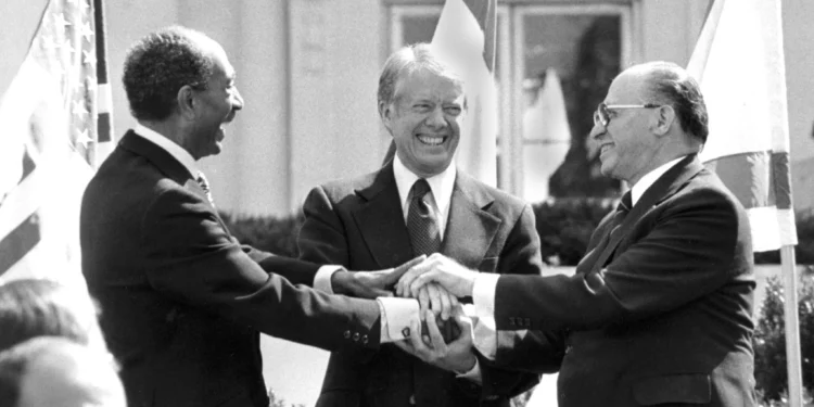 ARCHIVO - El presidente egipcio Anwar Sadat, a la izquierda, el presidente estadounidense Jimmy Carter, al centro, y el primer ministro israelí Menachem Begin se dan la mano en la Casa Blanca en Washington después de firmar el tratado de paz entre Egipto e Israel, el 26 de marzo de 1979. (Foto AP/Bob Daugherty, Archivo)