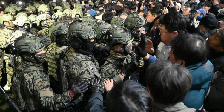 Los soldados intentan entrar en el edificio de la Asamblea Nacional en Seúl el 4 de diciembre de 2024, después de que el presidente de Corea del Sur, Yoon Suk Yeol, declarara la ley marcial. (Foto de Jung Yeon-je / AFP)