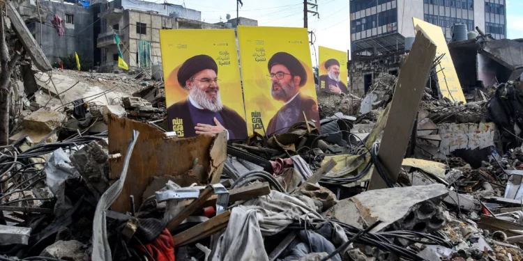 Carteles de los líderes asesinados de Hezbolá, Hassan Nasrallah (izq.) y Hashem Safieddine, se colocan en medio de la destrucción causada por los ataques israelíes en la ciudad de Nabatieh, en el sur del Líbano, el 4 de diciembre de 2024. (Mahmoud Zayyat/AFP)