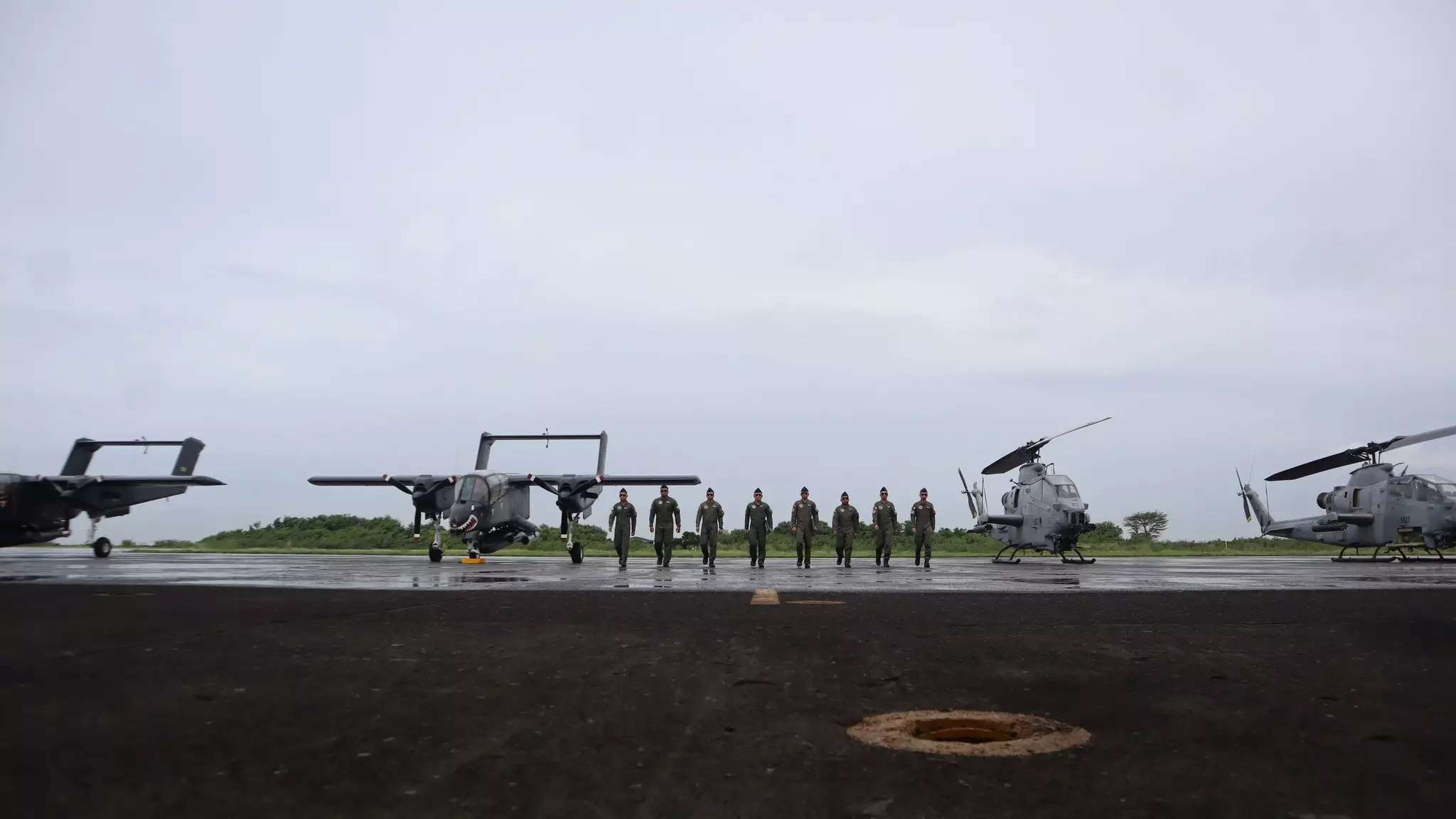 Los miembros del 15º Ala de Ataque marchan con los cuatro aviones en el fondo durante la ceremonia de desmantelamiento.