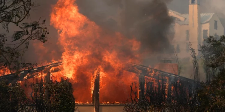 El incendio de Palisades arrasa un vecindario en medio de fuertes vientos en el barrio de Pacific Palisades de Los Ángeles, el 8 de enero de 2025. (Foto AP/Damian Dovarganes)