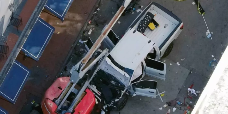 Una bandera negra con letras blancas yace en el suelo enrollada detrás de una camioneta que un hombre condujo contra una multitud en la calle Bourbon en Nueva Orleans, matando y hiriendo a varias personas, la madrugada del miércoles 1 de enero de 2025. (Foto AP/Gerald Herbert)