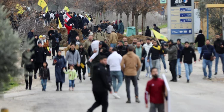 Libaneses con banderas de Hezbolá se reúnen cerca de las tropas israelíes en Burj al-Muluk, cerca de la aldea de Kfar Kila, en el sur del Líbano, donde las fuerzas israelíes permanecieron en el terreno después de que venciera la fecha límite para su retirada mientras los residentes intentaban regresar a sus hogares en la zona fronteriza, Líbano 26 de enero de 2025 (Reuters/Karamallah Daher)