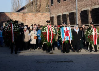 Los sobrevivientes, familiares y representantes del Memorial y Museo de Auschwitz-Birkenau colocan coronas de flores y encienden velas en el llamado Muro de la Muerte, junto al Bloque 11 del antiguo campo principal de Auschwitz I en Oswiecim, Polonia, el 27 de enero de 2025, durante las conmemoraciones del 80 aniversario de la liberación del campo de concentración y exterminio nazi alemán de Auschwitz-Birkenau por el Ejército Rojo. (Wojtek RADWANSKI / AFP)