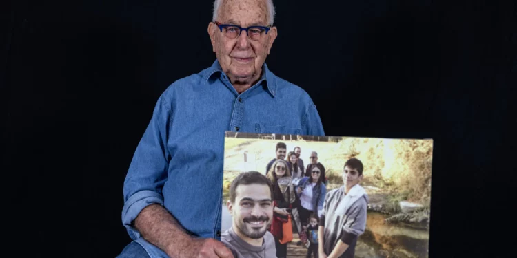 Naftali Furst, sobreviviente del Holocausto, sostiene una foto familiar tomada en Israel, mientras posa en su casa en la ciudad de Haifa, en el norte de Israel, el 28 de noviembre de 2024. (MENAHEM KAHANA / AFP)