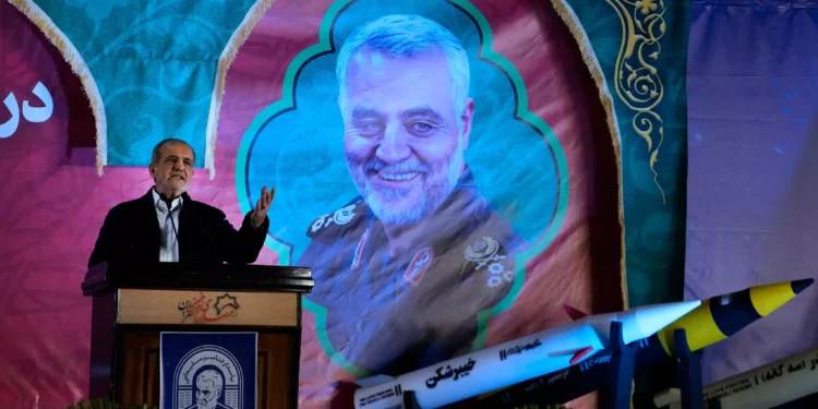 El presidente iraní, Masoud Pezeshkian, habla en una ceremonia que marca el aniversario de la muerte del general Qassem Soleimani, que aparece en la pancarta, quien murió en un ataque con drones estadounidenses en 2020, mientras se exhiben modelos de misiles fabricados en el país a la derecha, en la gran mezquita Imam Khomeini en Teherán, Irán, el jueves 2 de enero de 2025. (AP/Vahid Salemi)
