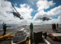 Un MH-60S Sea Hawk y un E-2D Hawkeye, asignados a los “Grey Hawks” del Escuadrón de Comando y Control Aerotransportado (VAW) 120, se aproximan a la cubierta de vuelo del USS Gerald R. Ford (CVN-78). (Fotografía de la Marina de los EE. UU. realizada por el especialista en comunicación de masas de segunda clase Maxwell Orlosky)