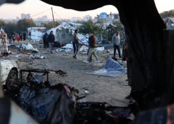 Palestinos caminan entre restos de tiendas de campaña el 2 de enero de 2025, tras un ataque israelí nocturno contra un campamento improvisado para desplazados en al-Mawasi, en el sur de la Franja de Gaza, que al parecer mató al menos a 11 personas, incluido el jefe de la policía de Hamás y su adjunto. (Foto de BASHAR TALEB / AFP)
