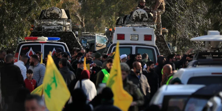 Soldados libaneses de pie en un vehículo rodeado de manifestantes que portan banderas de Hezbolá son vistos desde la ventana de un vehículo blindado de mantenimiento de la paz de la ONU, en la aldea de Mays al-Jabal, en el sur del Líbano, el 27 de enero de 2025. (Foto AP/Mohammad Zaatari)