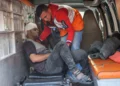 Un médico palestino ayuda a un hombre herido en ataques israelíes a desembarcar de una ambulancia en el hospital árabe Al-Ahli, también conocido como el hospital bautista, en la ciudad de Gaza el 13 de enero de 2025 (Foto de Omar AL-QATTAA / AFP)