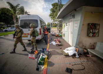 Soldados israelíes caminan junto a los cadáveres de personas asesinadas por terroristas de Hamás en la ciudad de Sderot, en el sur de Israel, el 7 de octubre de 2023. (Jamal Awad/Flash90)