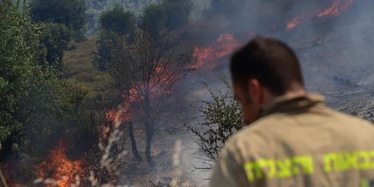 Los bomberos intentan extinguir un incendio después de que misiles lanzados desde el Líbano impactaran áreas abiertas cerca de la ciudad norteña de Safed, el 12 de junio de 2024. (Michael Giladi/Flash90)