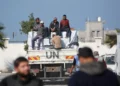 Los trabajadores se sientan en la parte trasera de un camión de la UNRWA durante una visita de un alto funcionario de emergencia de la agencia de la ONU para los refugiados palestinos (UNRWA) a Jan Yunis, en el sur de la Franja de Gaza, el 3 de diciembre de 2024. (BASHAR TALEB / AFP)