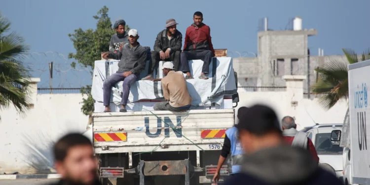 Los trabajadores se sientan en la parte trasera de un camión de la UNRWA durante una visita de un alto funcionario de emergencia de la agencia de la ONU para los refugiados palestinos (UNRWA) a Jan Yunis, en el sur de la Franja de Gaza, el 3 de diciembre de 2024. (BASHAR TALEB / AFP)