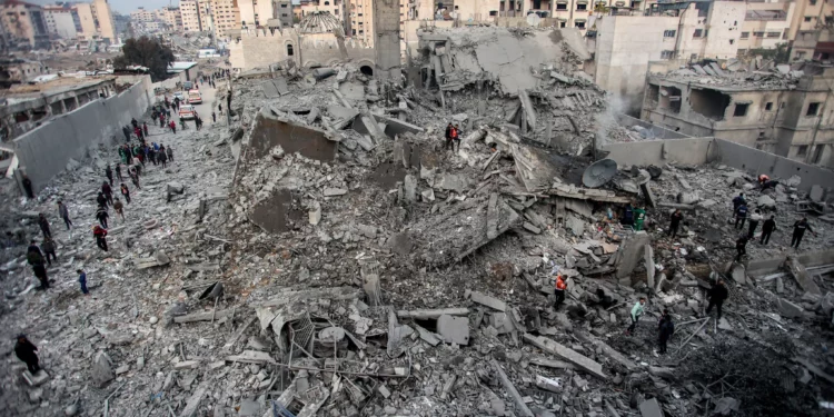 La gente inspecciona los escombros de un edificio derrumbado que fue alcanzado por los ataques israelíes en el área de Saraya en al-Rimal, en el centro de la ciudad de Gaza, el 4 de enero de 2025 (Foto de Omar AL-QATTAA / AFP)