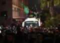 Jóvenes palestinos ondean banderas nacionales y pancartas de Hamás (verde) y Hezbolá (amarilla) mientras se sientan en el techo de un autobús de la Cruz Roja que transporta a decenas de terroristas presos liberados por Israel en la madrugada del 20 de enero de 2025, en la ciudad de Beitunia, en las afueras de Ramallah. (Foto de Zain JAAFAR / AFP)