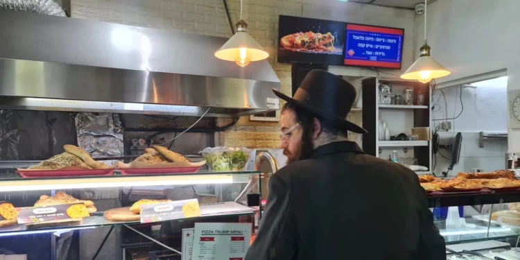 Un cliente elige porciones en Pizza Trump en Jerusalén, el 20 de enero de 2025. (Deborah Danan, vía JTA)