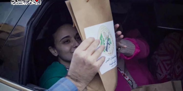 Esta imagen extraída de un video difundido por el grupo terrorista Hamás muestra a las rehenes israelíes Emily Damari (izq.) y Romi Gonen, recibiendo un paquete con el logo del brazo armado de Hamás, mientras están sentadas en un vehículo de Hamás antes de ser entregadas al Comité Internacional de la Cruz Roja en la Franja de Gaza el 19 de enero de 2025. (Captura de pantalla: Hamás/AFP)