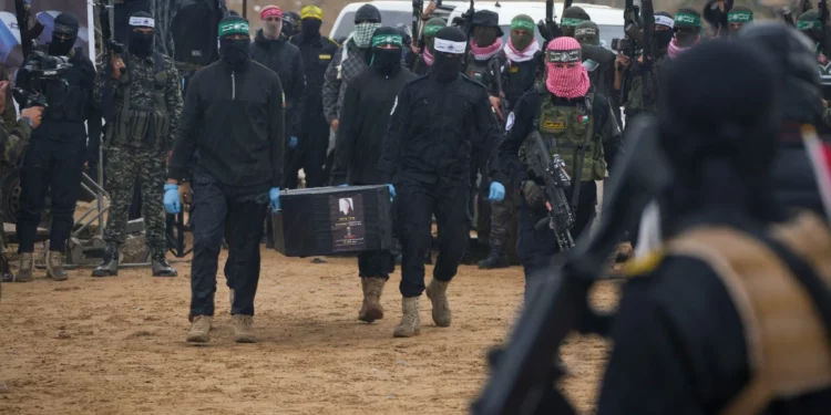 Terroristas de Hamás cargan el ataúd de un rehén israelí asesinado mientras entregan cuatro de esos ataúdes a la Cruz Roja en Jan Yunis, Gaza, el 20 de febrero de 2025. (Foto AP/Abdel Kareem Hana)