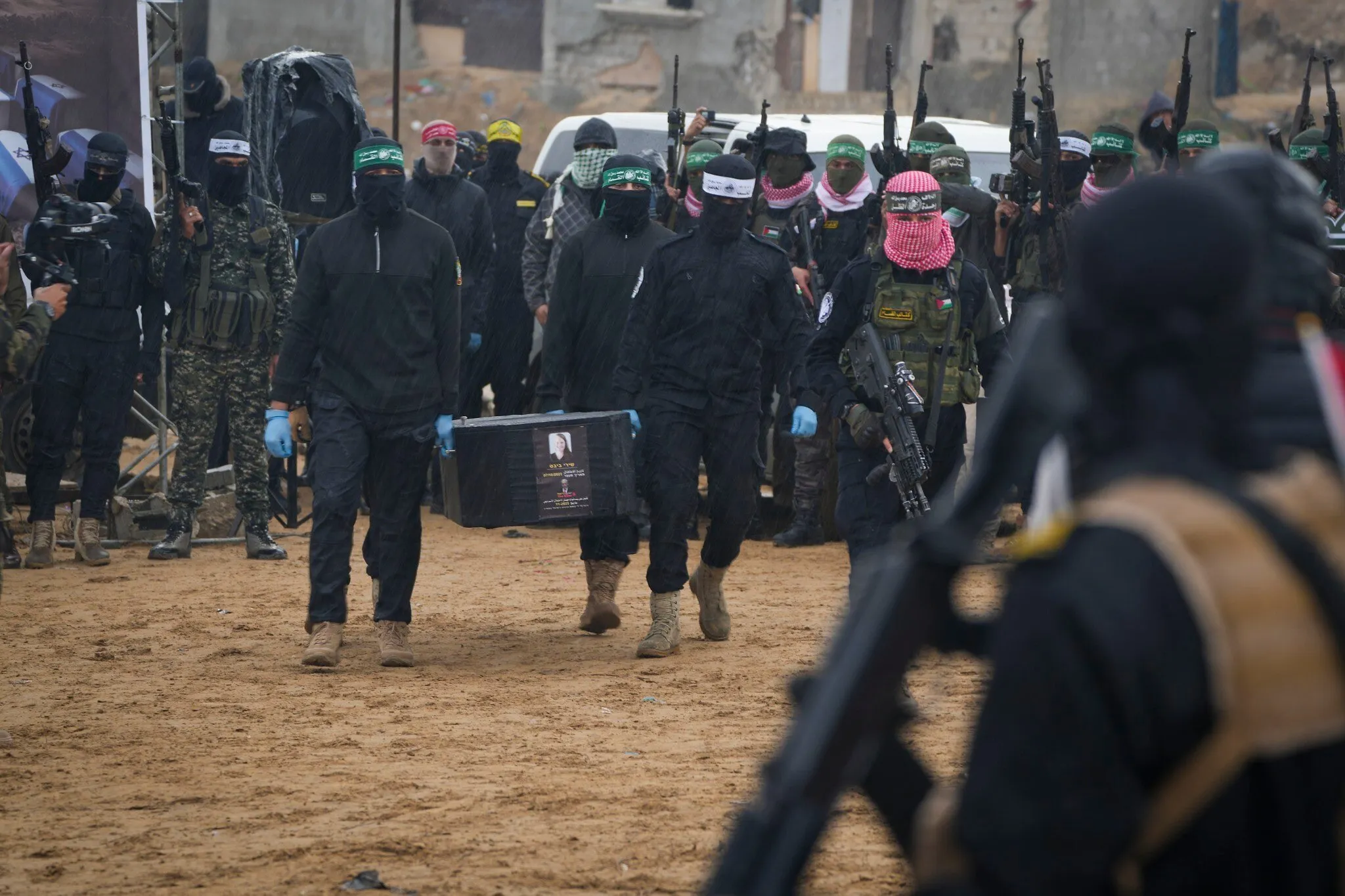 Terroristas de Hamás cargan el ataúd de un rehén israelí asesinado mientras entregan cuatro de esos ataúdes a la Cruz Roja en Jan Yunis, Gaza, el 20 de febrero de 2025. (Foto AP/Abdel Kareem Hana)