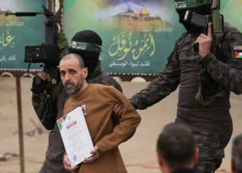 El rehén israelí Eli Sharabi, que se encuentra retenido como rehén por Hamas en Gaza desde el 7 de octubre de 2023, es paseado por hombres armados de Hamas antes de ser entregado a la Cruz Roja en Deir al-Balah, en el centro de la Franja de Gaza, el sábado 8 de febrero de 2025. (Foto AP/Abdel Kareem Hana)