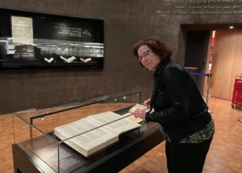 Rachel Neiman, portavoz de la Biblioteca Nacional de Israel, examina un manuscrito del siglo XV que contiene Mezukak Shivatayim ('Destilado siete veces'), un comentario previamente perdido sobre la Misheh Torá de Maimonines que se exhibe en la Biblioteca Nacional de Israel en febrero de 2025. (Rossella Tercatin/Times of Israel)