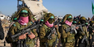 Hombres armados de Hamás, vestidos con uniformes de las Fuerzas de Defensa de Israel capturados y blandiendo armas israelíes, forman una formación antes de la liberación de rehenes en Jan Yunis, Franja de Gaza, el sábado 15 de febrero de 2025. (Foto AP/Abdel Kareem Hana)