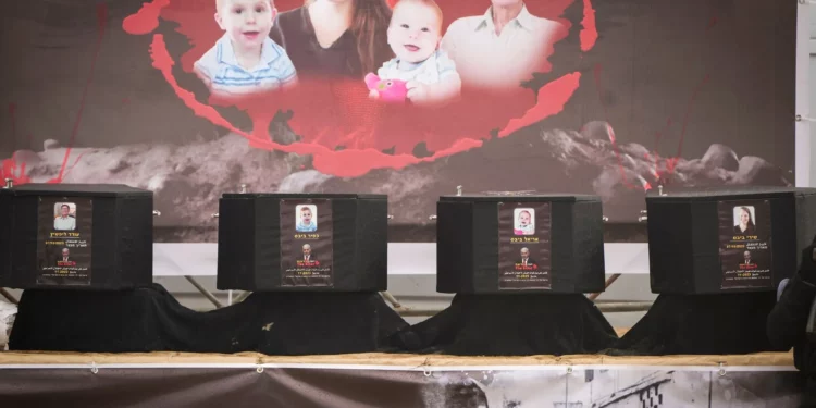 Ataúdes que aparentemente contienen los cuerpos de los rehenes israelíes asesinados Shiri Bibas, sus dos hijos Ariel y Kfir, y Oded Lifshitz, son exhibidos en un escenario con un mensaje de propaganda antes de ser entregados a la Cruz Roja por terroristas de Hamás y la Yihad Islámica en Jan Yunis, Franja de Gaza, el 20 de febrero de 2025. (Foto AP/Abdel Kareem Hana)