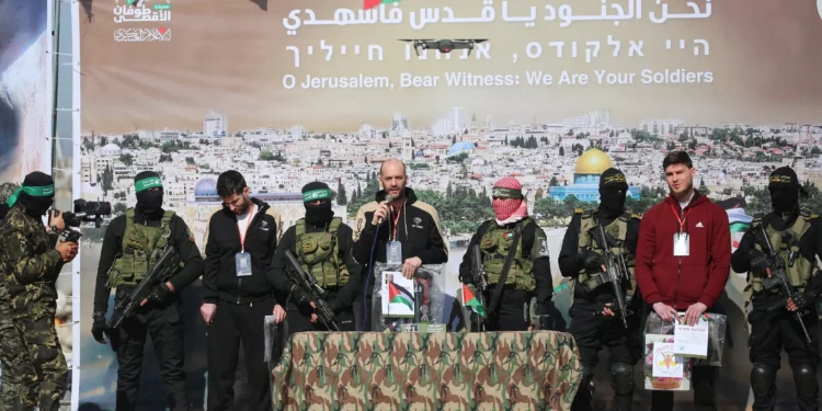 Rehenes de izquierda a derecha: Sagui Dekel-Chen, Iair Horn y Sasha Trupanov están en el escenario junto a hombres armados de Hamas y la Jihad Islámica durante su entrega a un equipo de la Cruz Roja en Khan Yunis, en el sur de la Franja de Gaza, el 15 de febrero de 2025 (Eyad BABA / AFP)