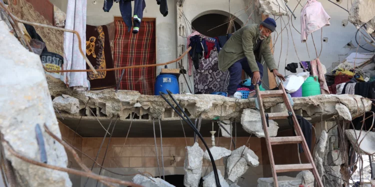 Un hombre palestino usa una escalera para salir de su casa dañada en Jabaliya, en el norte de la Franja de Gaza, el 4 de febrero de 2025. (Omar AL-QATTAA / AFP)