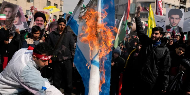 Manifestantes iraníes queman una representación de la bandera israelí durante una manifestación en conmemoración del aniversario de la Revolución Islámica de 1979 que derrocó al fallecido Sha Mohammad Reza Pahlavi, pro estadounidense, y llevó a los clérigos islámicos al poder, en Teherán, Irán, el 10 de febrero de 2025. (Vahid Salemi/AP)