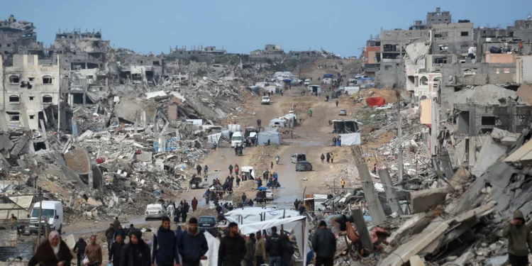 Palestinos desplazados caminan por un camino fangoso en medio de la destrucción en Jabaliya, en el norte de la Franja de Gaza, el 6 de febrero de 2025. (Bashar TALEB / AFP)