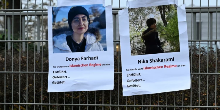 Carteles con fotos de la iraní Nika Shakarami (derecha) y Donya Farhadi, ambas presuntamente víctimas de las fuerzas de seguridad iraníes, se ven en una valla durante una manifestación contra las ejecuciones en Irán frente al Consulado general de la República Islámica de Irán en Frankfurt am Main, Alemania occidental, el 31 de octubre de 2024 (Kirill KUDRYAVTSEV / AFP)