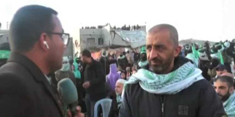 El terrorista liberado de Hamás Mohammad Abu Warda (derecha) aparece en una transmisión televisiva de la ceremonia de entrega de rehenes israelíes asesinados en Jan Yunis, el 20 de febrero de 2025. (Captura de pantalla de X, utilizada de conformidad con la cláusula 27a de la Ley de Derechos de Autor)