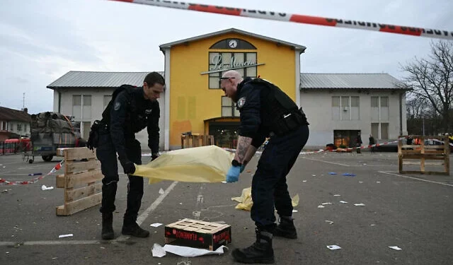 Oficiales de la policía municipal francesa trabajan para recolectar evidencia en el lugar de un ataque con arma blanca donde un hombre es sospechoso de matar a una persona y herir a dos oficiales de policía municipales en Mulhouse, este de Francia, el 22 de febrero de 2025. (SEBASTIEN BOZON / AFP)