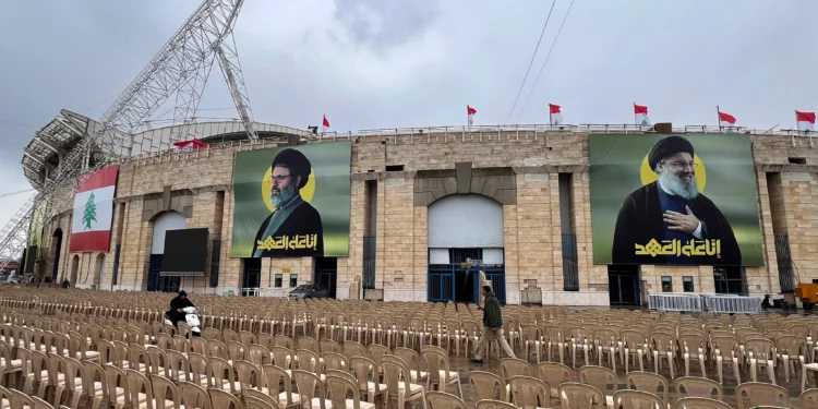 La gente pasa entre sillas instaladas en el exterior del estadio City Sportive de Beirut, un día antes de la procesión fúnebre de los líderes de Hezbolá Sayyed Hassan Nasrallah y Sayyed Hashem Safieddine, en Beirut, Líbano, el sábado 22 de febrero de 2025. (Foto AP/Hussein Malla)