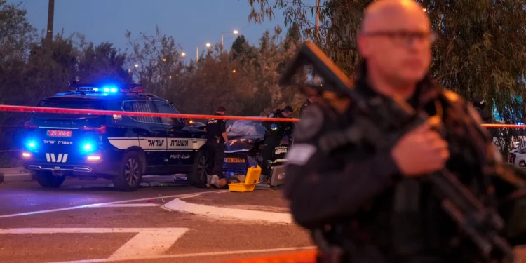 Israeli police officers examine the body of a terror suspect who rammed his car into a highway bus stop near Gan Shmuel, Israel, on Thursday, February 27, 2025. (AP/Ariel Schalit)