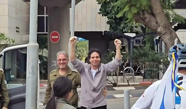 El rehén liberado Ofer Calderón levanta ambas manos y lanza besos a sus amigos afuera del Centro Médico Sheba a su regreso a Israel, el 1 de febrero de 2025 (Eyal Hadani/AFP)