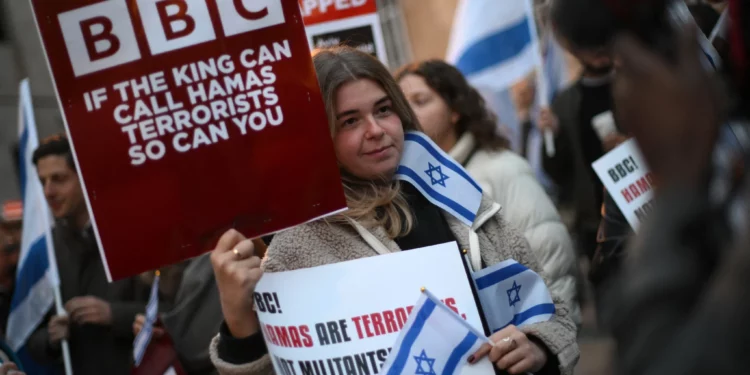 Ilustrativo: Manifestantes con pancartas y banderas israelíes participan en una concentración frente a la sede de la BBC (British Broadcasting Corporation) en Londres el 16 de octubre de 2023, para pedir a la corporación que llame a Hamás "terrorista". (Daniel Leal/AFP)